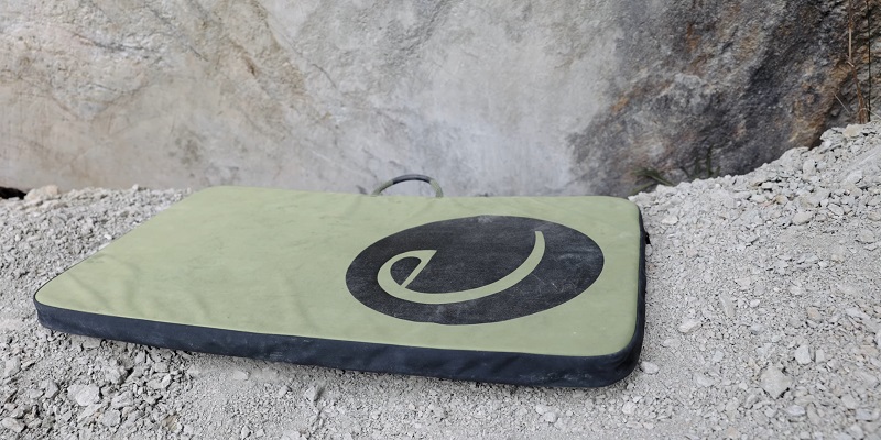 Lightweight crash pad laid out on rocky terrain for solo bouldering sessions