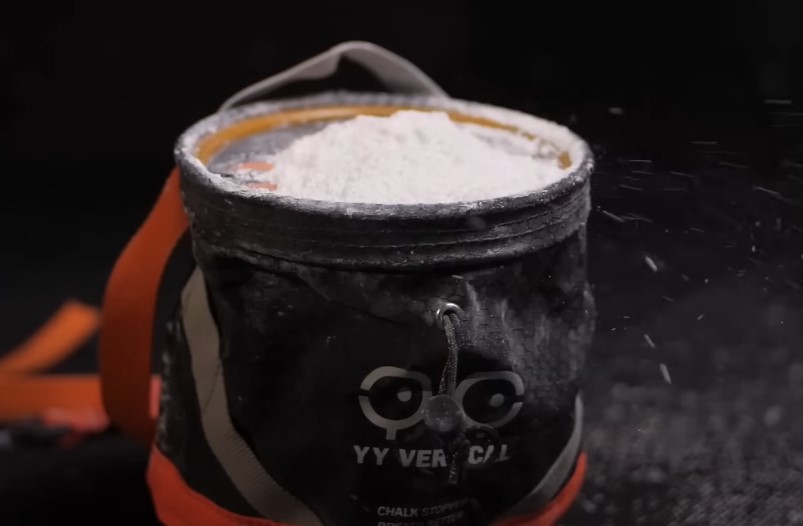 A climbing chalk bag, filled to the brim with fine, white powder